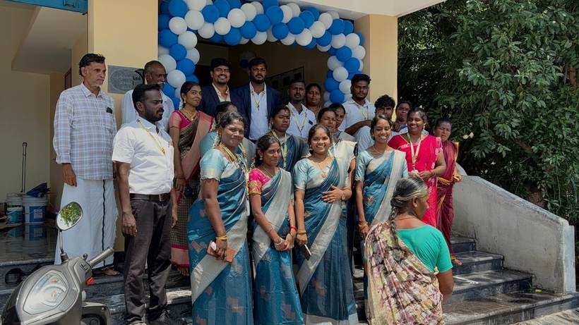 Staff and guests outside the new branch under a balloon arch